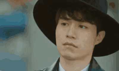 a close up of a man wearing a hat and making a face .