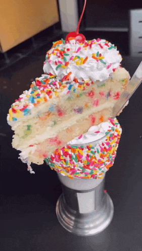 a cake with sprinkles and whipped cream on top