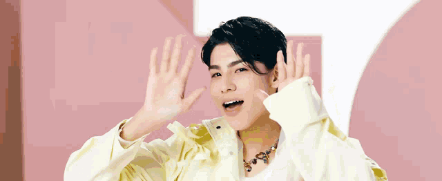 a young man wearing a white shirt and a yellow jacket making a funny face