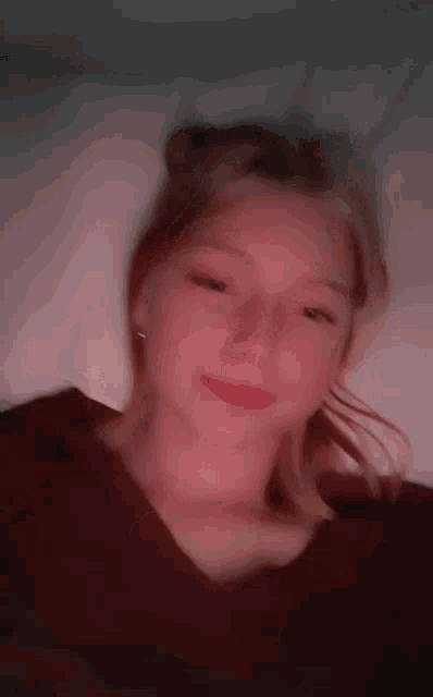 a close up of a woman 's face with a red shirt on