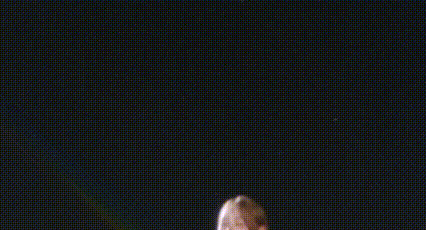 a couple of girls are dancing on a stage in front of a black background .