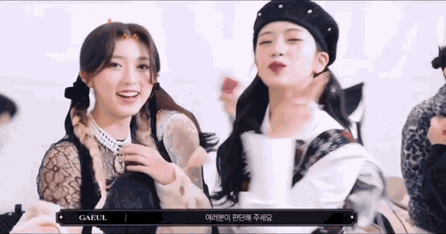 two girls are standing next to each other and one of them is wearing a beret with pearls on it