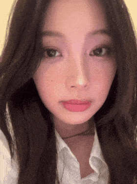 a close up of a woman 's face with a white shirt