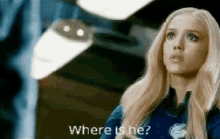 a woman with blonde hair is standing in a room and asking where is he .