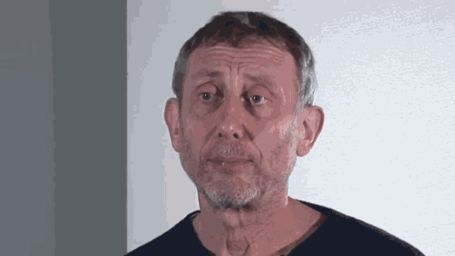 a man with a beard and a blue shirt looks at the camera