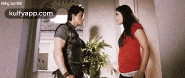 a man and a woman are standing next to each other and the website kulfyapp.com is in the corner
