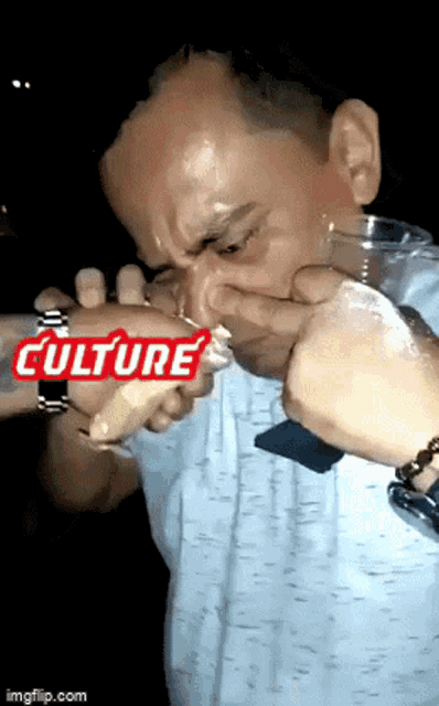 a man is drinking from a glass with the word culture written on it