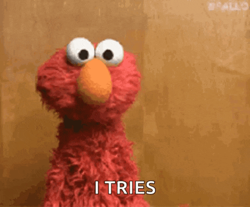 elmo from sesame street is making a funny face and saying i tries .