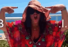 a woman wearing a hat and sunglasses is pointing her fingers at the number 3 and 1