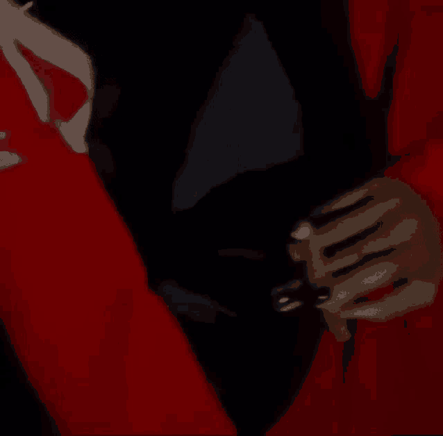 a close up of a person wearing a red jacket and black shirt .