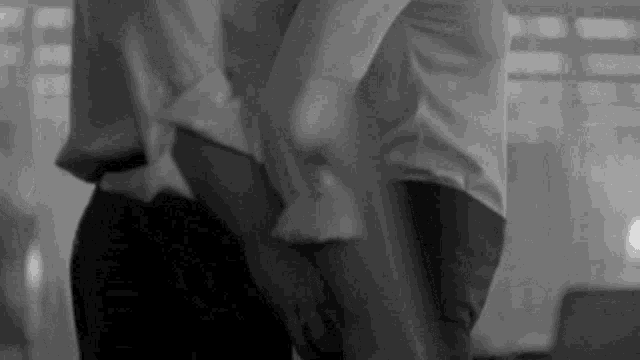 a black and white photo of a man and woman dancing together .