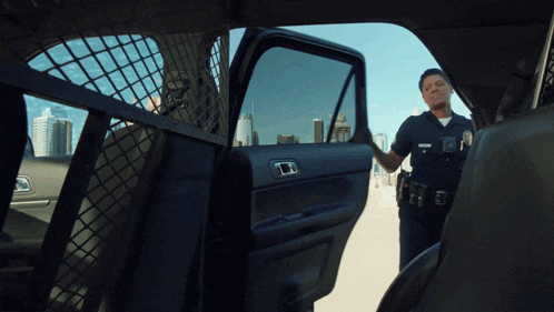 a police officer is standing in the back of a car