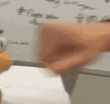 a blurred image of a person writing on a whiteboard