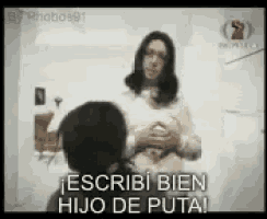a man is standing in front of a woman who is holding her breasts and says " escribi bien hijo de puta "
