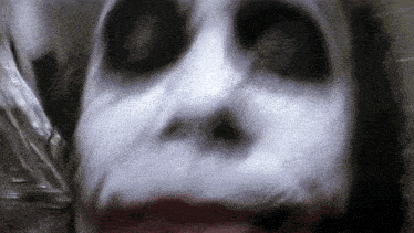 a close up of a person 's face with white paint on it and red lips