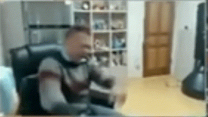a blurry picture of a man sitting at a desk in a living room .