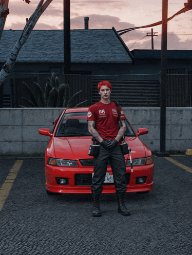 a man standing in front of a red car that says rh