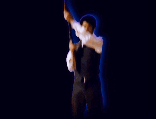 a man in a suit is holding a torch in his hand