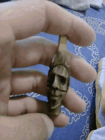 a person is holding a small object in their hand with the letter p on it