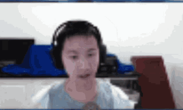 a blurry picture of a person wearing headphones and looking at the camera .