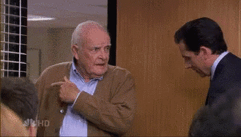 a man in a suit and tie is talking to another man