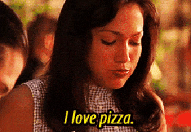 a woman says " i love pizza " while eating a pizza