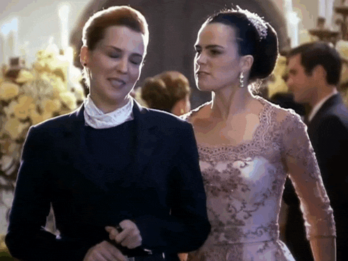 a man in a suit and a woman in a dress are walking together .