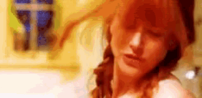 a close up of a woman 's face with her eyes closed and her hair in a braid .