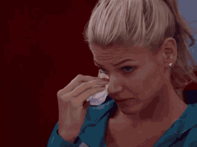 a woman wipes her eye with a napkin