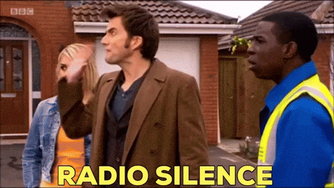 a group of people standing in front of a house with the words radio silence written in yellow letters .