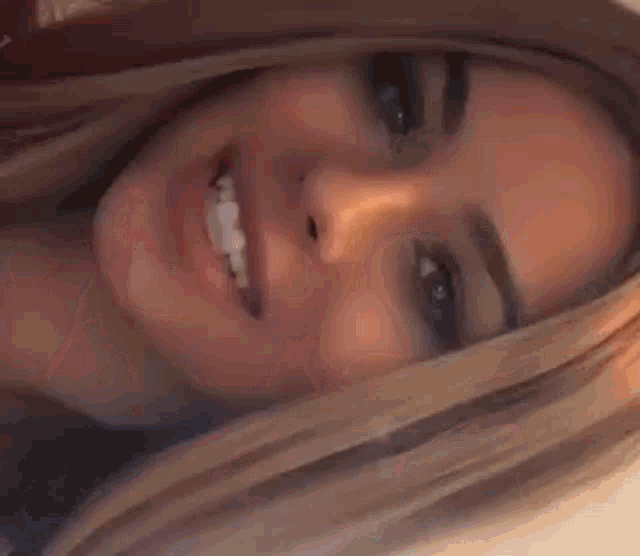 a close up of a woman 's face with long blue nails .