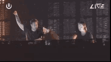 a group of men are standing in front of a screen that says live on it