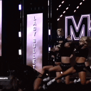 a group of cheerleaders are dancing in front of a sign that says ladybug