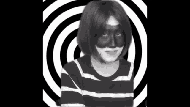 a woman wearing a black and white striped shirt and a black mask