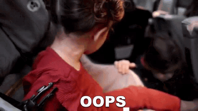 a girl in a red shirt is sitting next to a man in a car seat with the words oops written on the bottom