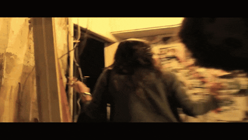 a blurry picture of a woman walking in a dark room