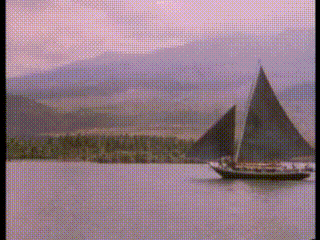 a sailboat is floating on a body of water with mountains in the background