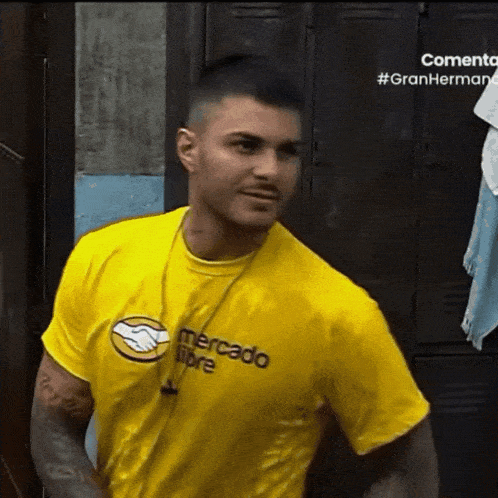 a man wearing a yellow mercado libre t-shirt