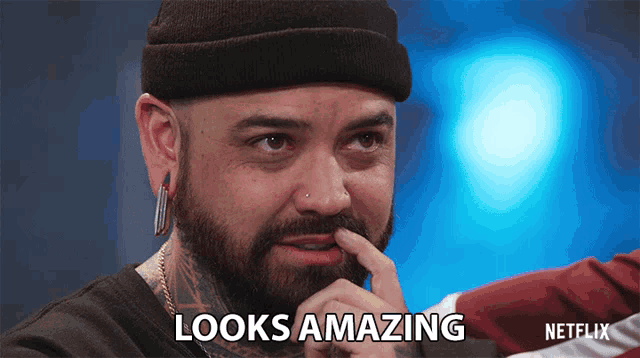 a man with a beard is making a funny face and says looks amazing