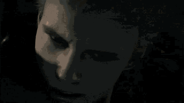 a man in a hooded jacket looks down at something