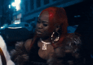 a blurry picture of a woman with red hair and a necklace