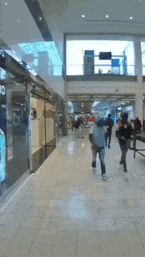 people are walking in a mall with a sign that says ' jc ' on it