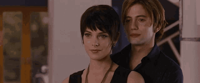 a man and a woman are standing next to each other in a room