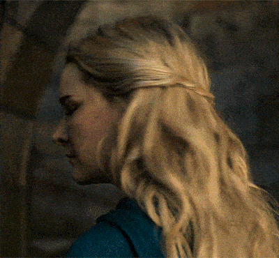 a woman with blonde hair and a blue shirt is looking down
