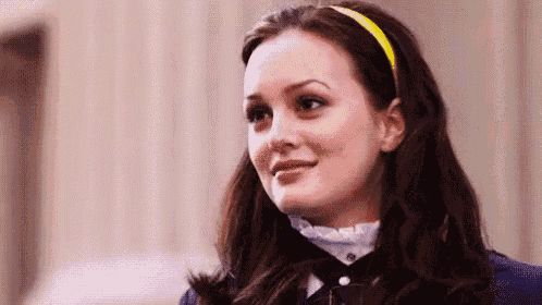 a woman wearing a yellow headband is smiling and looking at the camera .