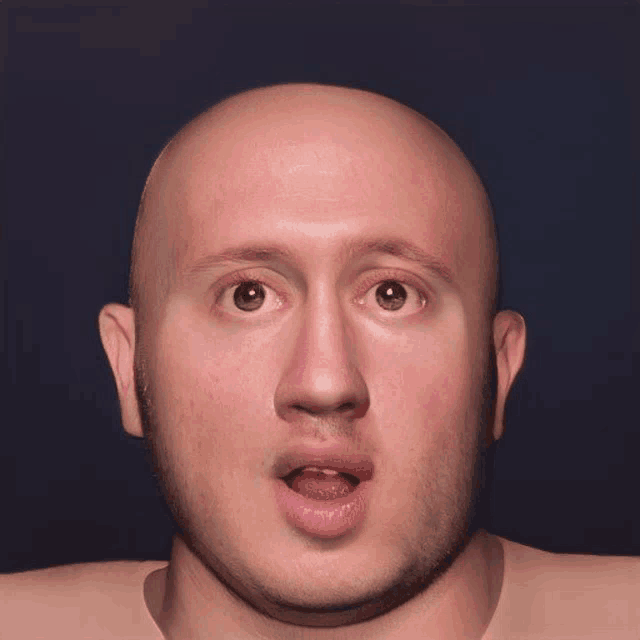 a bald man with a beard has his mouth open