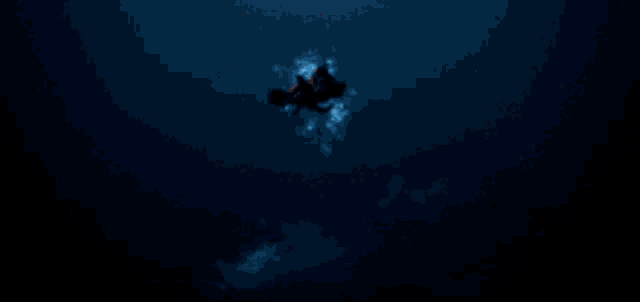 a pixel art of a person swimming in the water with a blue light behind them .