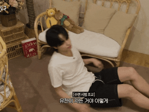 a man in a white shirt is laying on the floor next to a chair