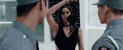 a woman in a black dress is being inspected by two men