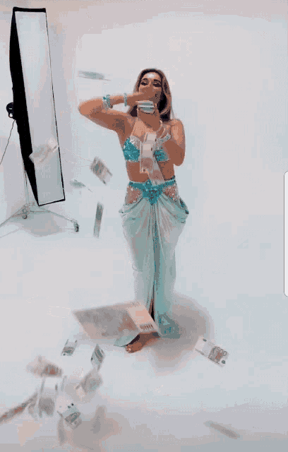 a woman in a mermaid costume is holding a cell phone